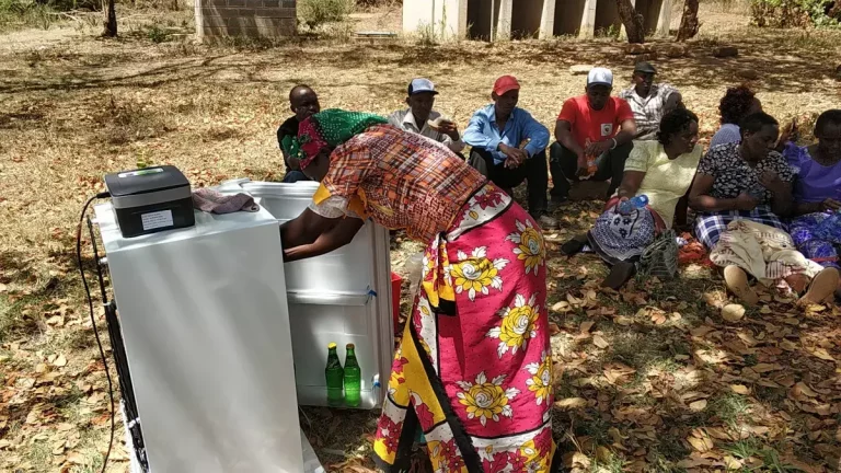 mulher em comunidade do Quênia usando o refrigerador