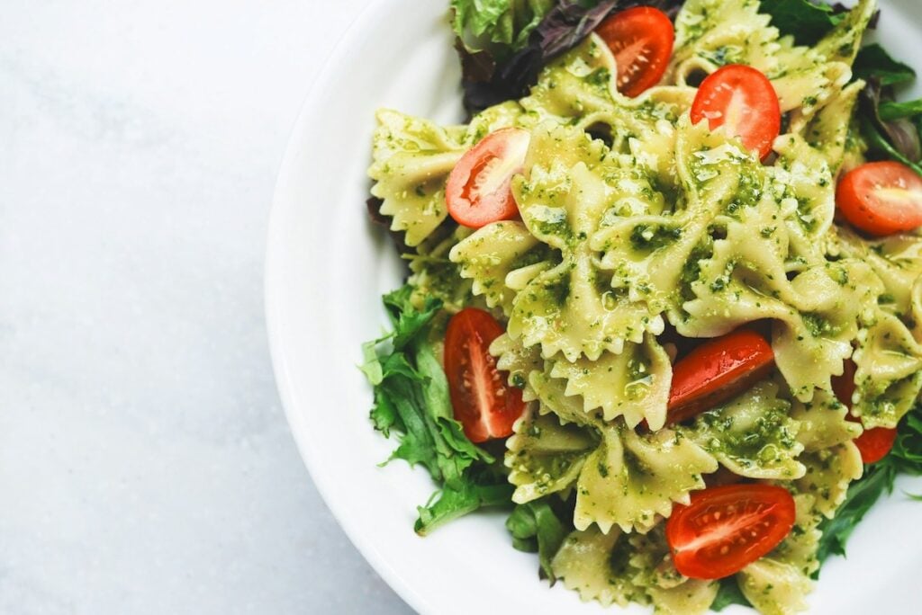 Macarrão pesto com tomates fatiados festivais gastronômicos
