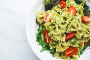 Macarrão pesto com tomates fatiados festivais gastronômicos