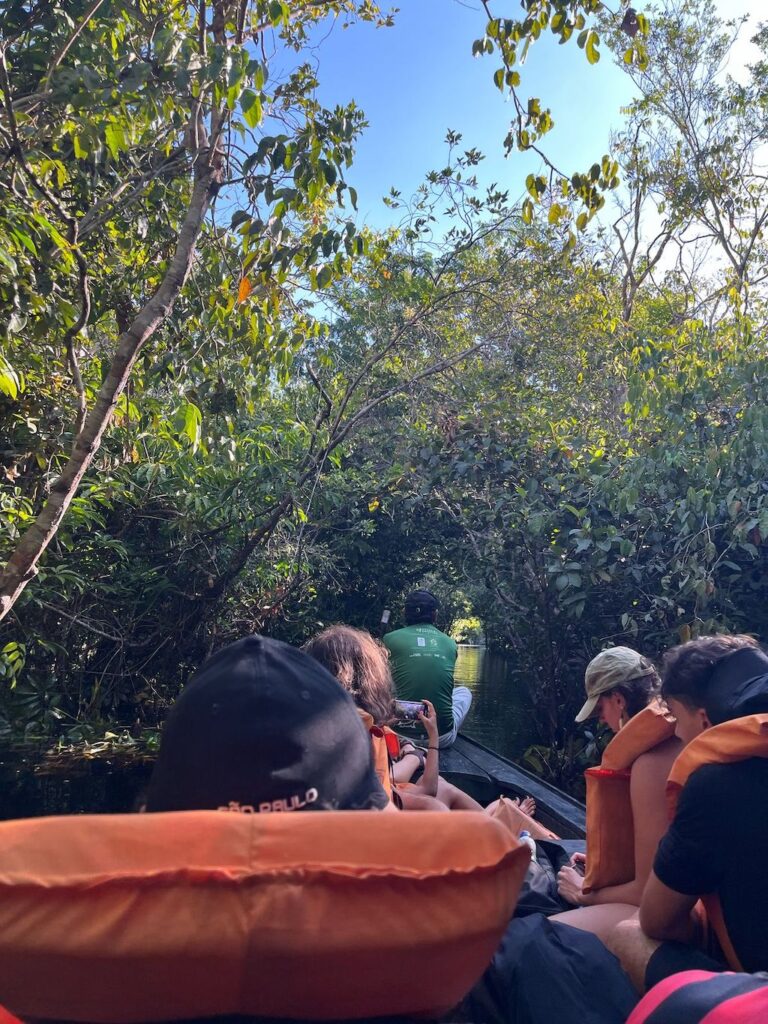 jovens sentados em barco na amazonia