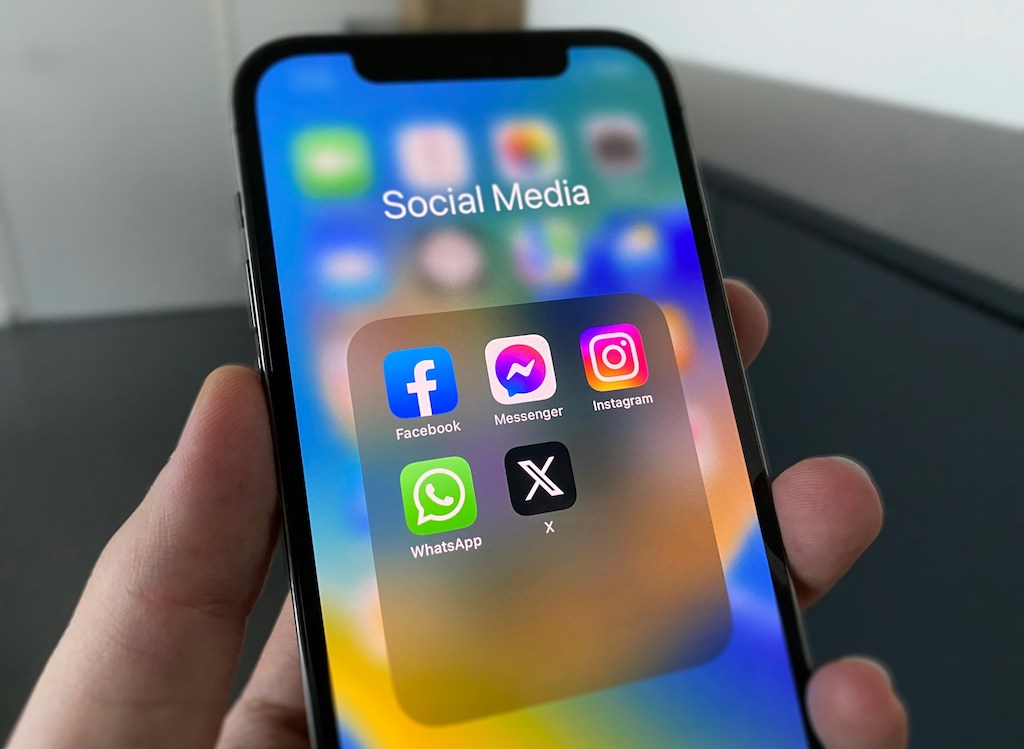pessoa segurando um celular com as redes sociais na tela
